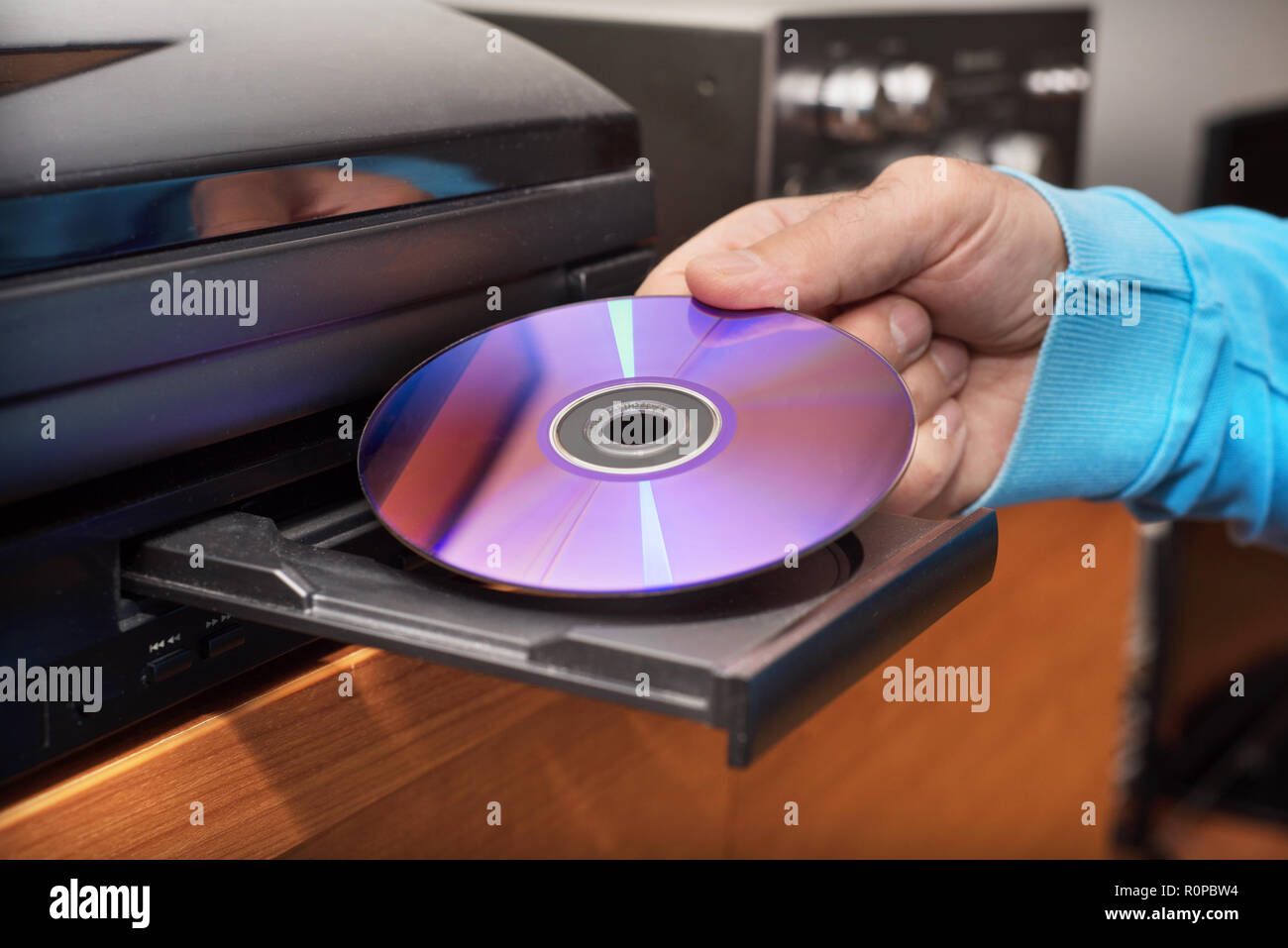 Mano azienda inserendo il DVD di video player Foto Stock