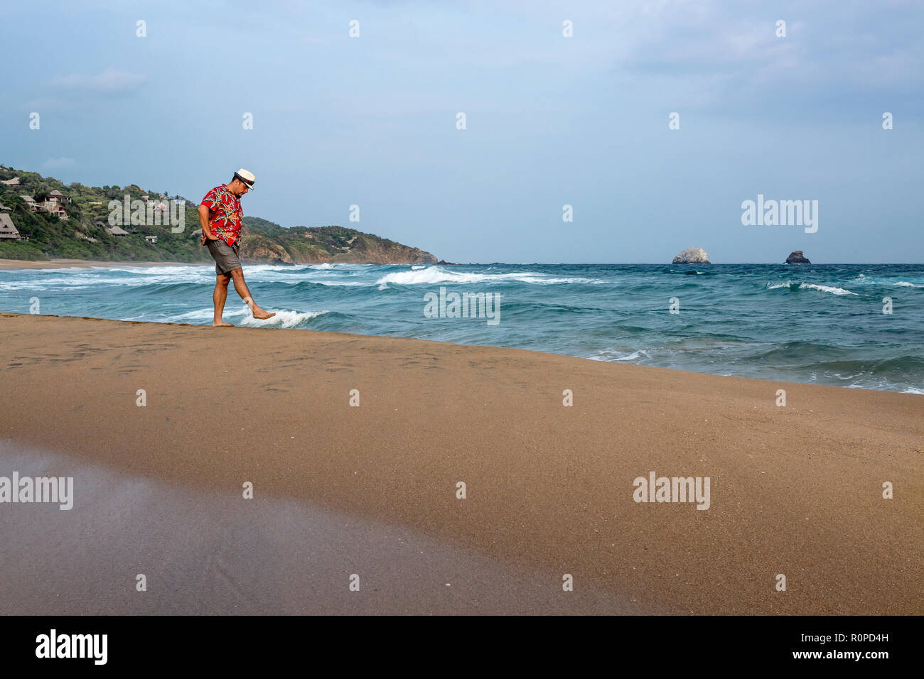 Latin American l uomo nella sua quarantina passeggiando lungo l'Oceano Pacifico, San Agustinillo beach, Stato di Oaxaca, Messico, America del Nord Foto Stock