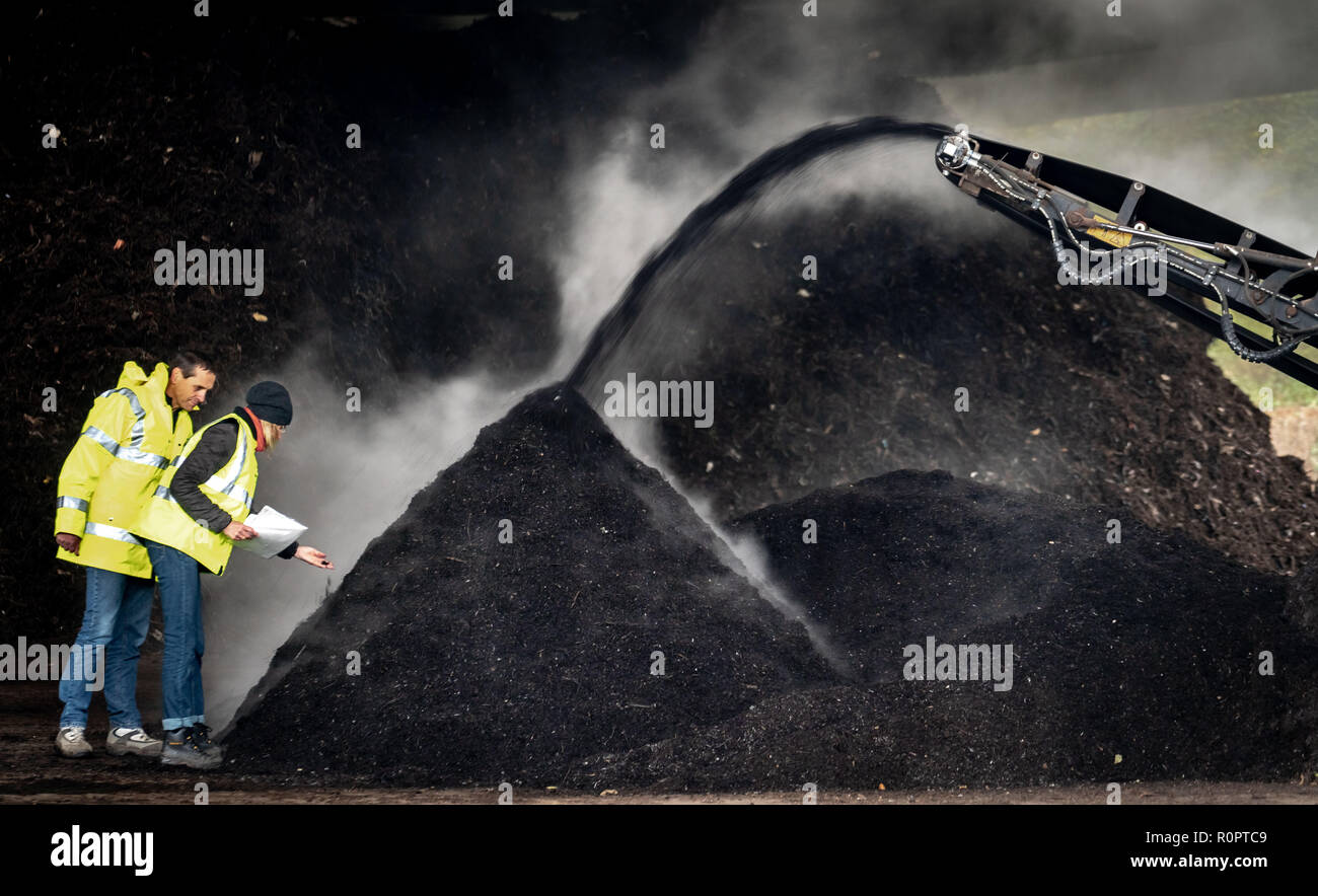 02 dicembre 2016, Assia, Frankfurt/Main: Jürgen Roth (l), Managing Director di Wetterau Abfallwirtschaft, ingegnere e Birgit Simon (r) sono in piedi in humus e impianto di suolo su un crescente montagna di compost fresco per l'agricoltura. L'azienda elabora circa 36.000 tonnellate di organico e verde rifiuti dal distretto di Wetterau ogni anno. Questo viene utilizzato per produrre energia, compost, suolo e fertilizzante liquido. (A dpa 'Biowaste - dal raccoglitore al campo e nella presa' del 07.11.2018) Foto: Frank Rumpenhorst/dpa Foto Stock