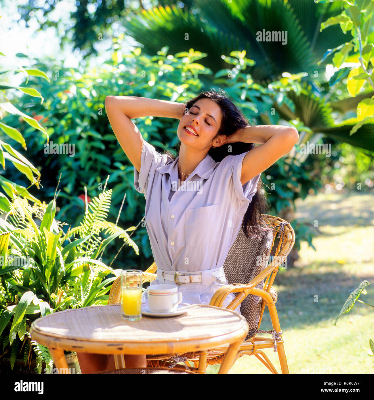 Giovane donna stretching nel giardino tropicale, Guadalupa, French West Indies, Foto Stock