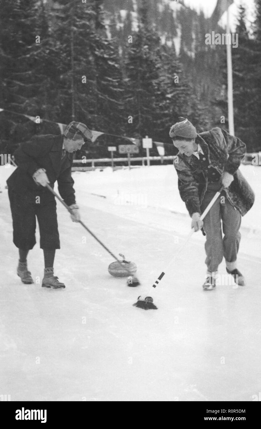 Sport invernali nel 1940s. Due giovani donne sono in concorrenza nell'annuale torneo di curling ad Åre in Svezia nel 1940s. Foto Stock