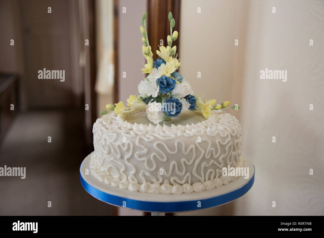Close up della torta di nozze tier, mostrando la decorazione sul ghiaccio e fiori di glassa sulla parte superiore della torta di nozze Foto Stock