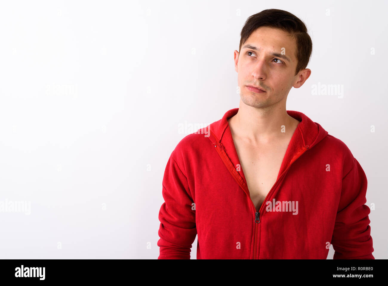 Chiusura del giovane uomo bello pensare guardando in alto contro Foto Stock