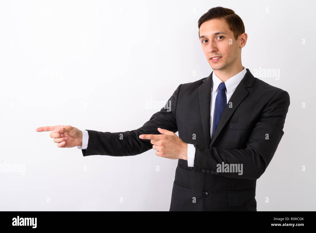 Studio shot del giovane imprenditore bello mostrando qualcosa whil Foto Stock