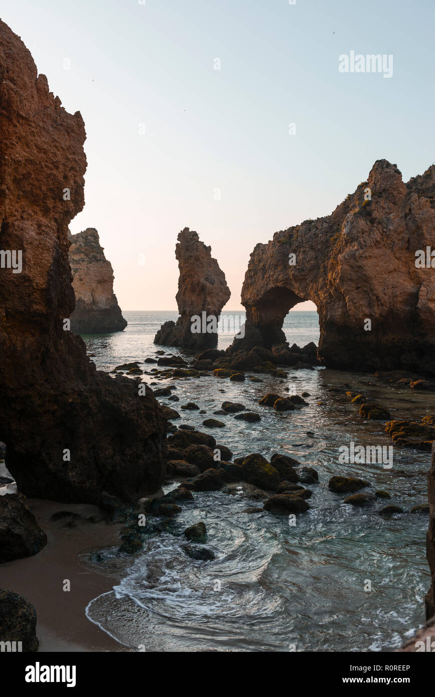 Arco di roccia, sassi in mare, Algarve costa di roccia, Ponta da Piedade, Lagos, Portogallo Foto Stock
