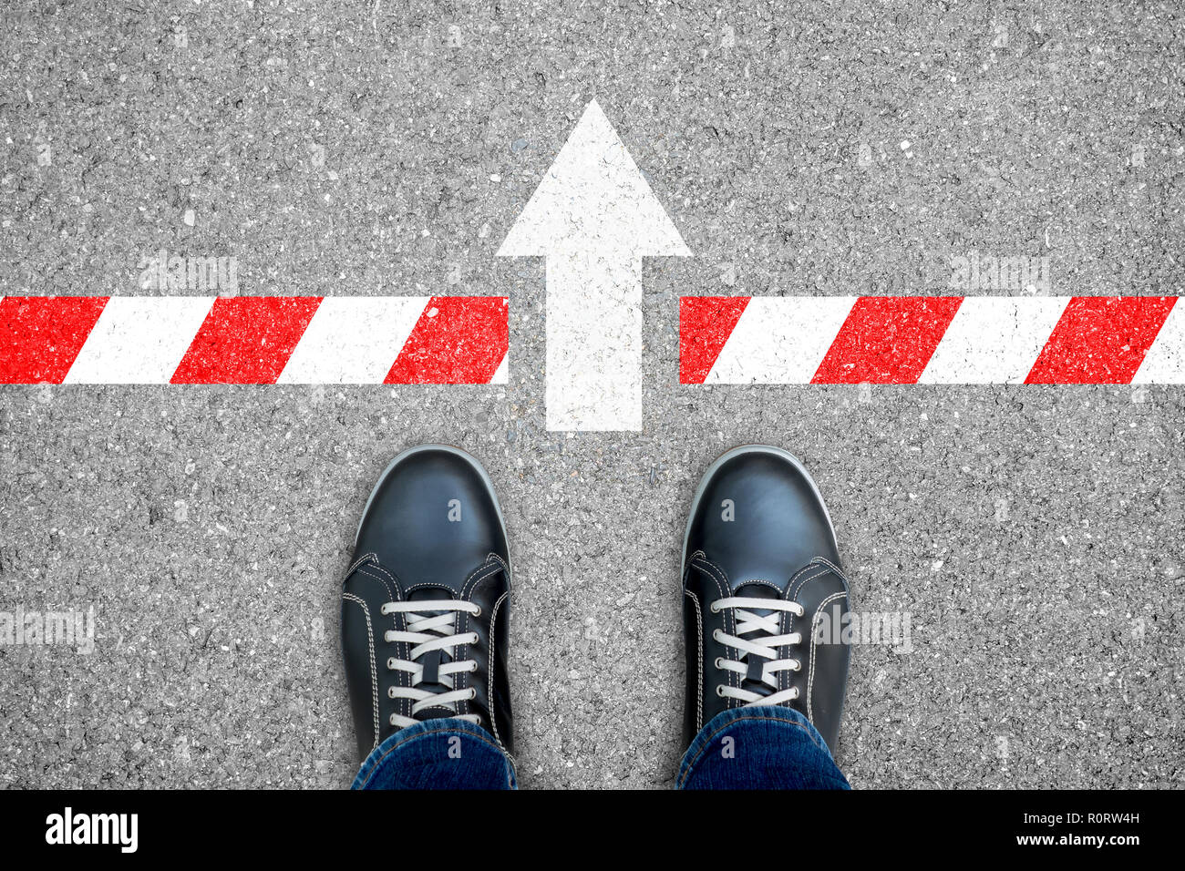 Scarpe nere in piedi al limite ma segno di direzione spingere attraverso il vicolo cieco in linea che rappresentano il modo di uscire fuori. Foto Stock