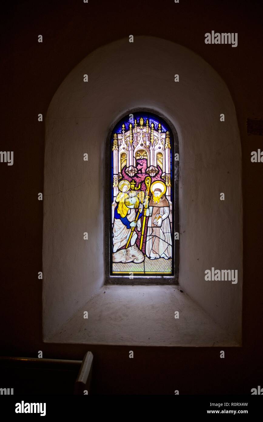 Le finestre di vetro macchiate, vista interna St Seiriol la Chiesa, Penmon, Anglesey, Galles del Nord, Regno Unito Foto Stock