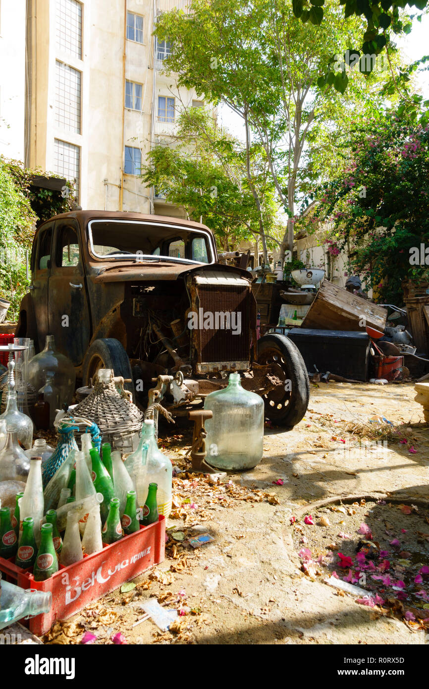Giardino sul retro piena di spazzatura e di antiquariato e una vecchia auto arrugginito. A nord di Nicosia, Cipro Nord Ottobre 2018 Foto Stock