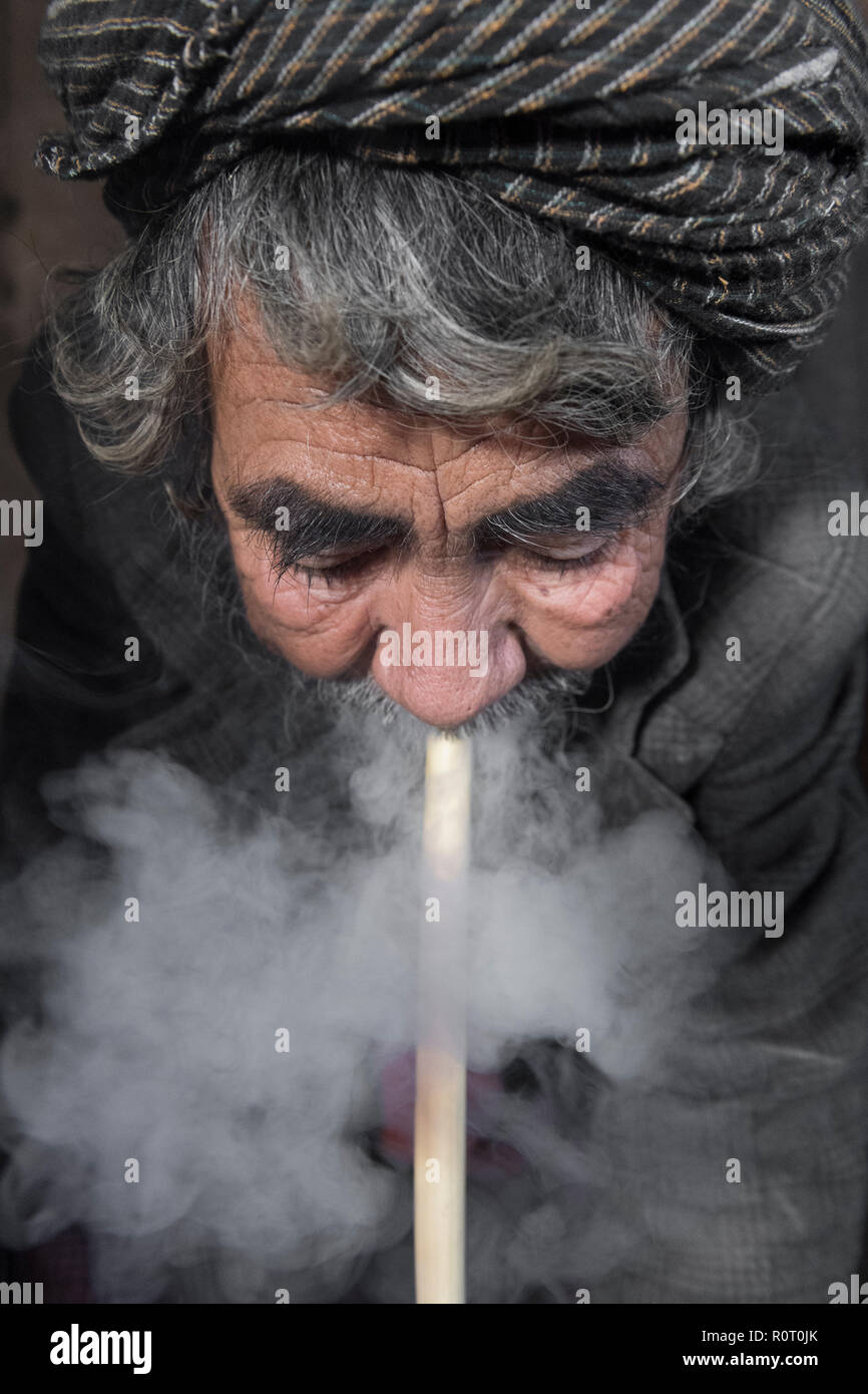 Vecchio Eremita Sufi fuma Home Grown-Hashish oltre a prendere cura del santuario Sufi, Balkh Provincia, Afghanistan Foto Stock