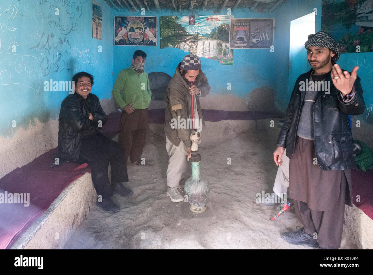 Gli uomini di fumare hashish con un bong vicino alla tomba di un santo Sufi, antica Balkh, Nord Afghanistan Foto Stock