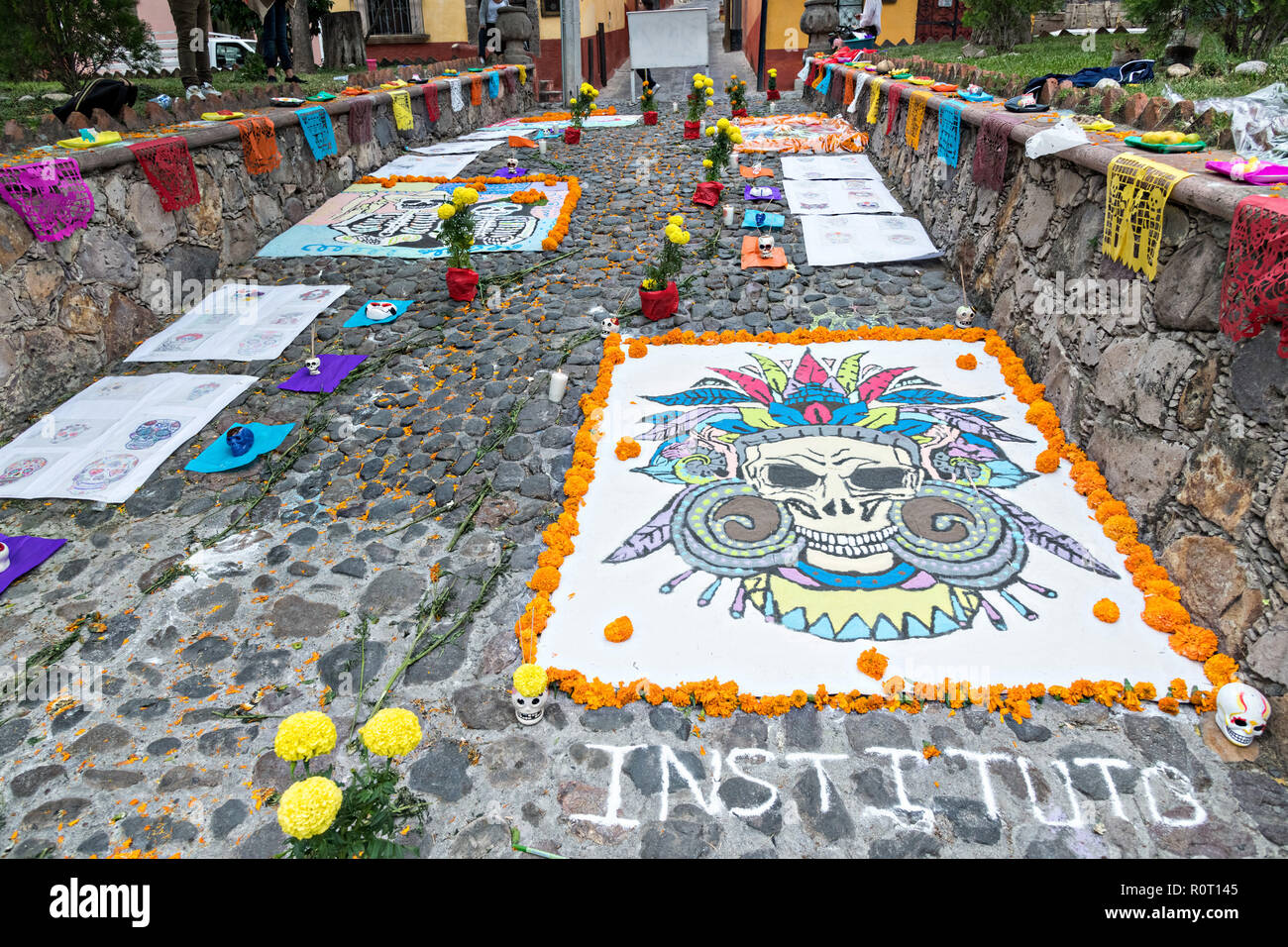 Morti di morti dipinti di sabbia sul display al di fuori di San Juan de Dios Chiesa durante la Dia de Muertos festival di San Miguel De Allende, Messico. Il multi-day festival è quello di ricordare gli amici e i familiari che sono morti utilizzando calaveras, azteca Le calendule, alfeniques, papel picado e i cibi preferiti e bevande dei defunti. Foto Stock