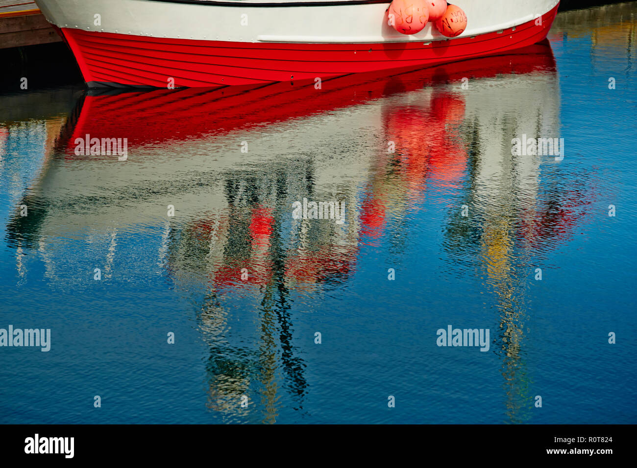 Norvegia, riflesso della barca di pesce in acqua specchio, la pesca affronta, blu e rosso Foto Stock