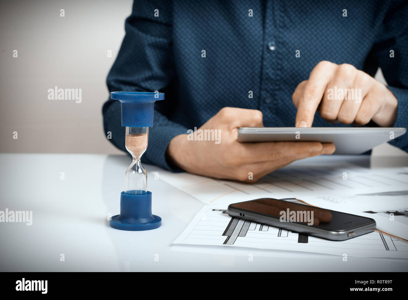 Close up di imprenditore il canto analizzando il grafico su tavoletta digitale. Il tempo è denaro concetto. Foto Stock