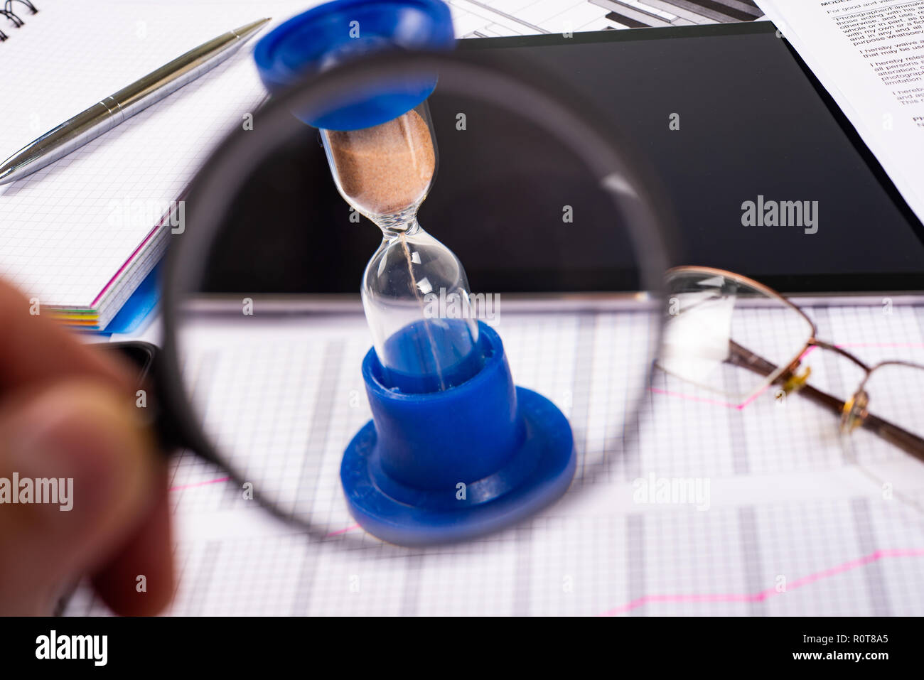 Clessidra. Imprenditore lavora in ufficio in background. Concetto il tempo è denaro. Foto Stock