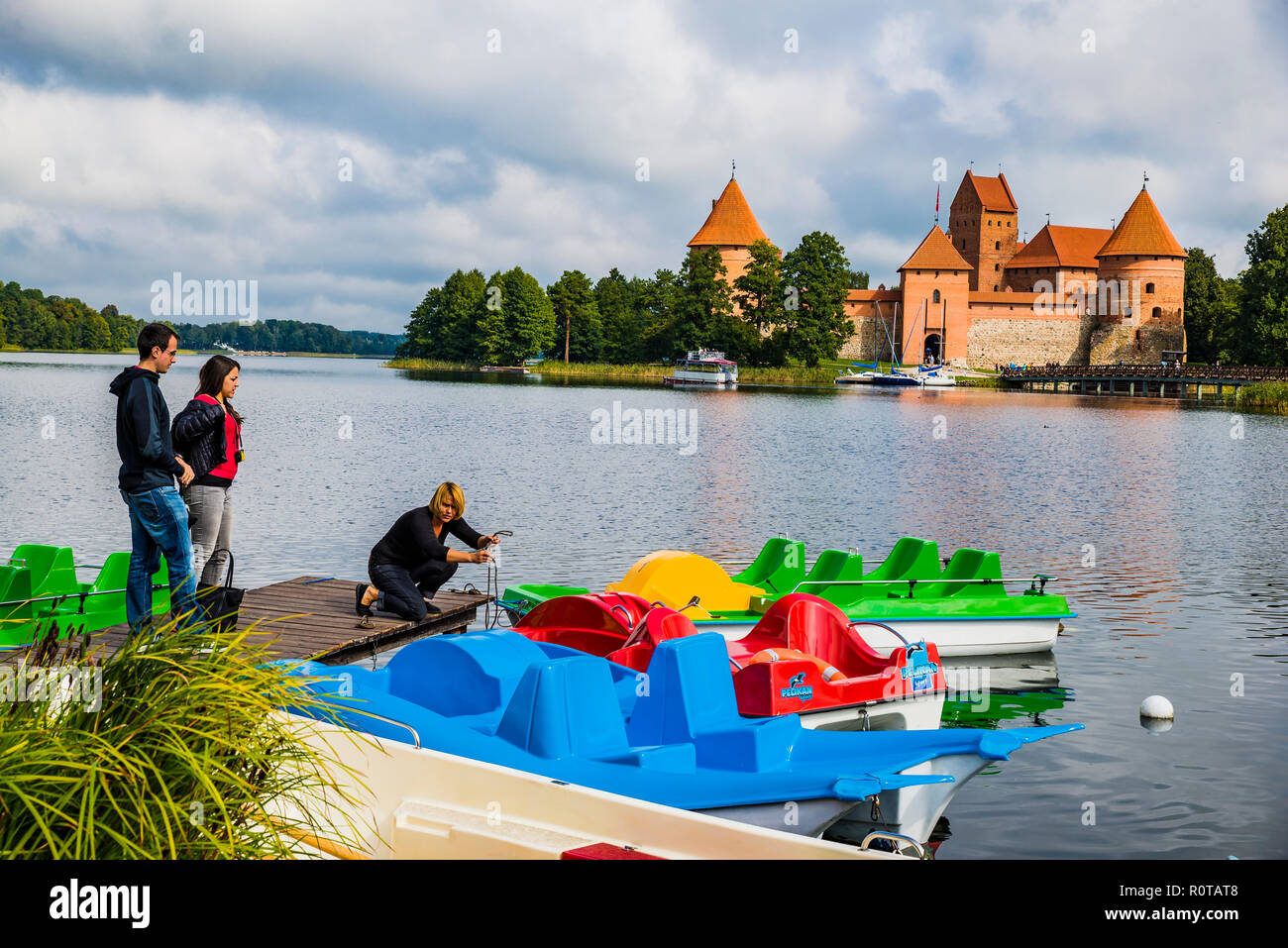 Barche per i turisti di fronte all'Isola di Trakai Castle. Trakai, Contea di Vilnius, Lituania, paesi baltici, Europa. Foto Stock