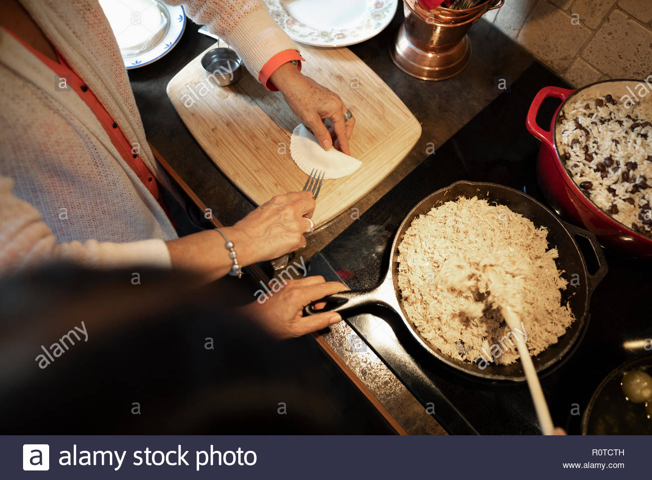 Donna Latinx cucinare le empanadas in cucina Foto Stock