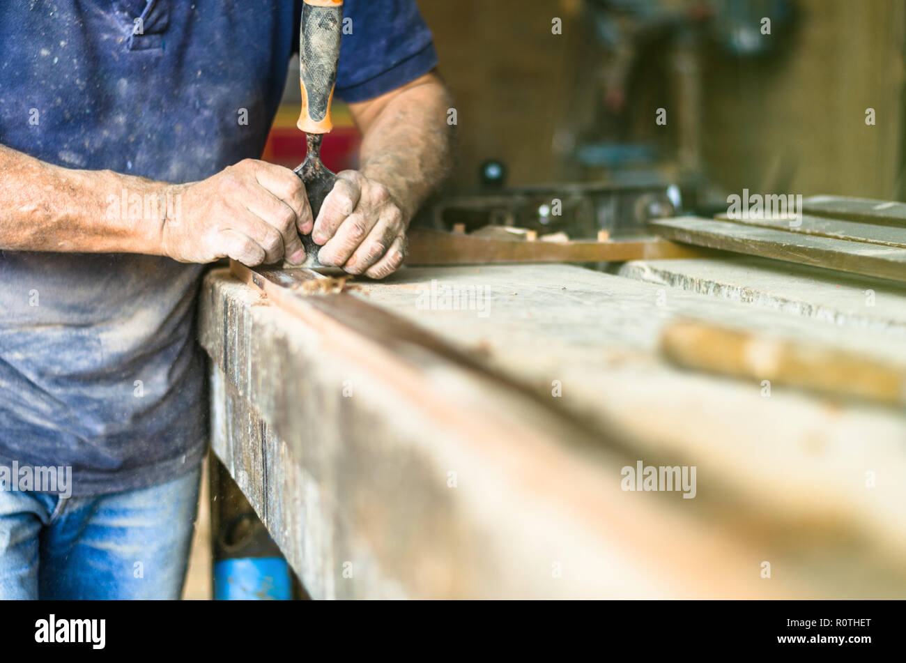 Professional carpenter al lavoro, egli è il carving legno utilizzando un utensile per la lavorazione del legno e falegnameria artigianale e di concetto Foto Stock