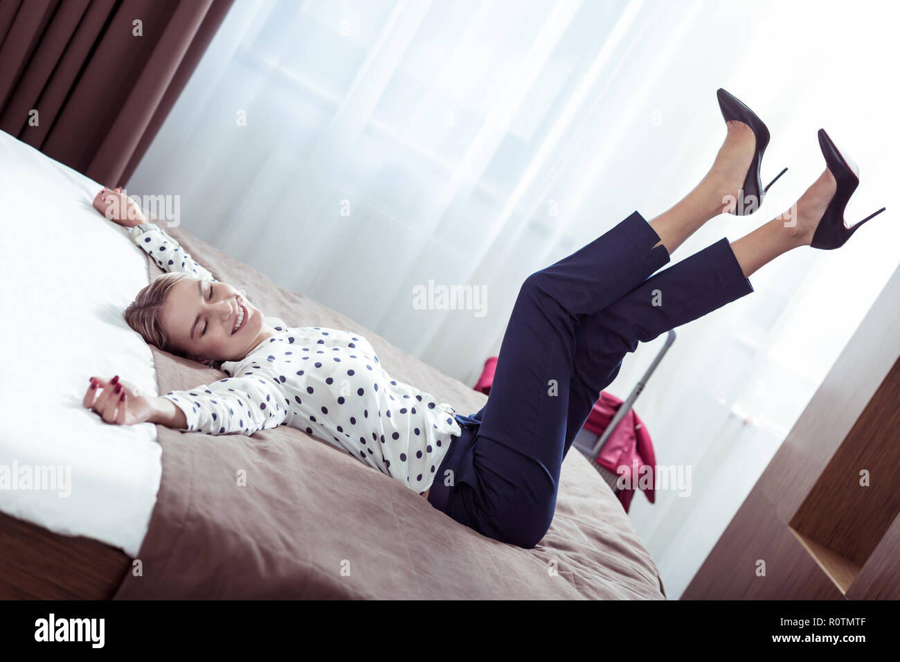 Elegante imprenditrice indossando scarpe con i tacchi alti sdraiato sul  letto in hotel Foto stock - Alamy