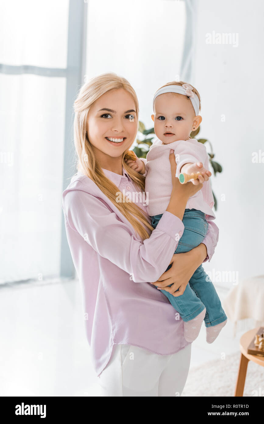 Giovani sorridente azienda madre figlia dei bimbi con scacchi figura in mano Foto Stock