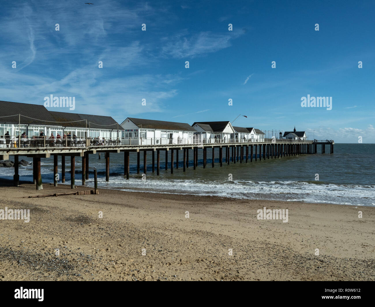 Una vista di Southwold pier in una limpida giornata di sole dalla spiaggia con la bassa marea Foto Stock