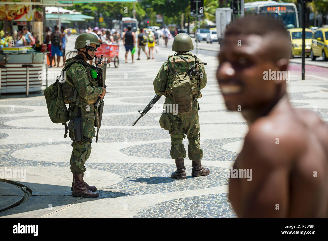 RIO DE JANEIRO - circa Febbraio, 2018: soldati armati in pieno supporto uniforme di protezione sulla spiaggia di Copacabana, il riempimento di un vuoto di sicurezza a sinistra da un colpo di polizia Foto Stock