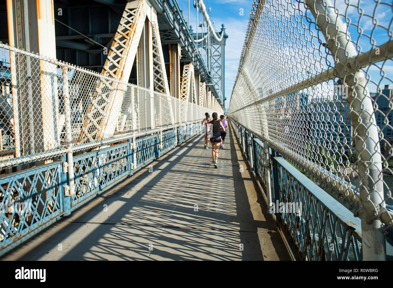 Vista astratta di sole del pomeriggio gettando ombre lungo il sentiero pedonale che attraversa il ponte di Manhattan a New York City, Stati Uniti d'America Foto Stock