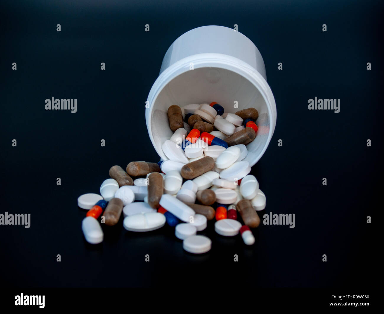 Una pentola di pillole di varie dimensioni, forme e colori. Concetto di salute Foto Stock