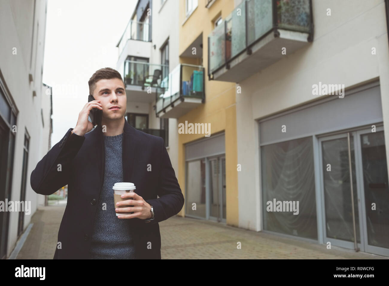 Uomo che utilizza il cellulare mentre un caffè Foto Stock