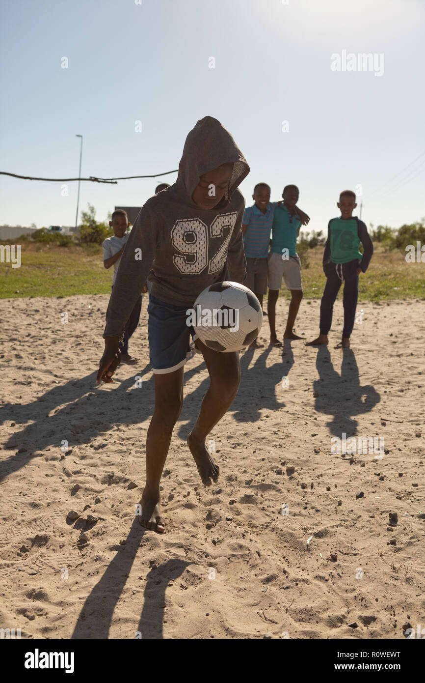Ragazzo giocando a calcio nel terreno Foto Stock