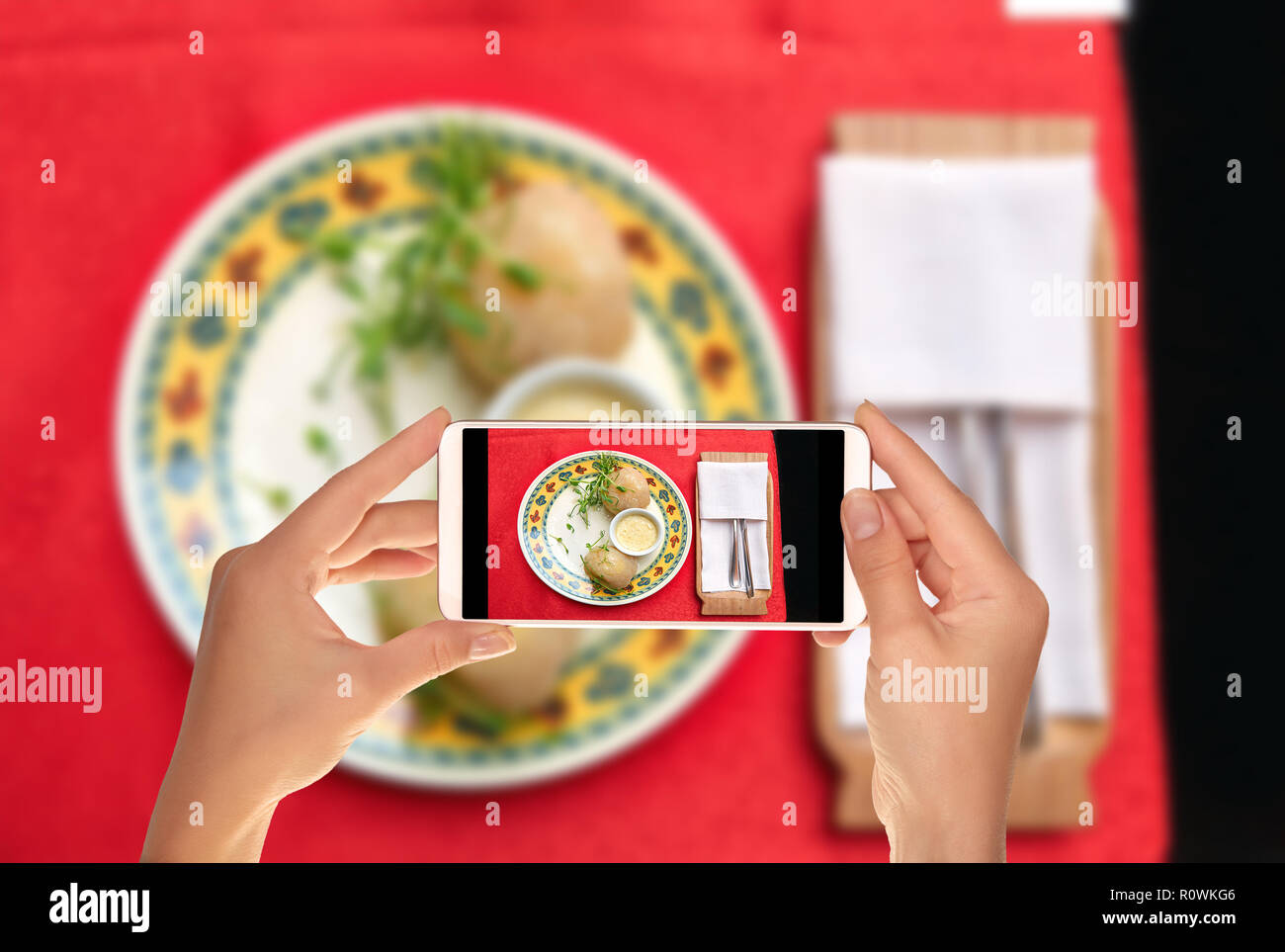 Un turista è di scattare una foto di tradizionali piatti lituani da patate - dirigibili con salsa su una piastra su un telefono cellulare Foto Stock