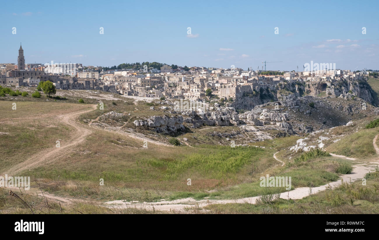 Foto panoramica di case costruite nella roccia nella grotta storica città di Matera (Sassi di Matera), Basilicata Italia. Sperone roccioso in primo piano. Foto Stock