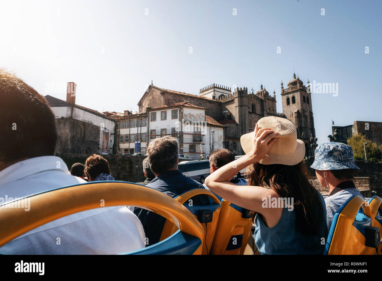 Porto, Portogallo. I turisti su open top bus turistico hop on hop off di esplorare la città. Cattedrale Seu sullo sfondo Foto Stock