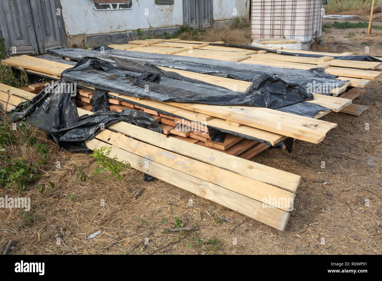 Una pila di tavole di pino imbevuto in una soluzione antisettica è essiccato sul sito di costruzione. Costruzione di materiali per la costruzione di un telaio house. Foto Stock