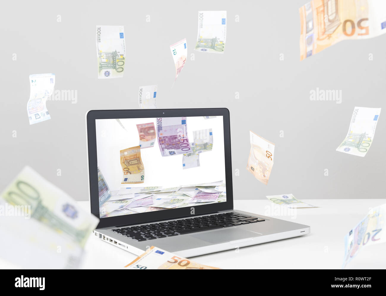 Online Einkaufen, Laptop und fliegende EURO-Scheine Foto Stock