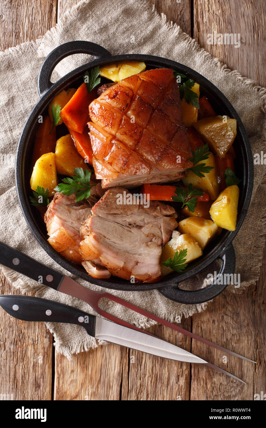 La birra bavarese arrosto di maiale, noto anche come Bayerischer Schweinebraten Krustenbraten o con verdure close-up in una padella. Verticale in alto vista dal Foto Stock