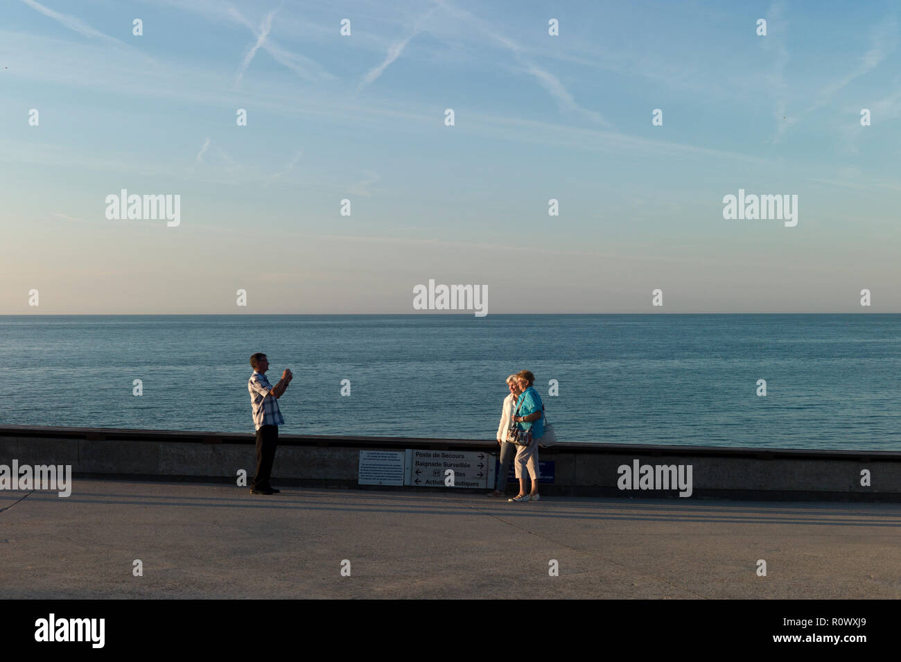 Uomo di fotografare due donne sul lungomare, Veules-les-Roses, Normandia, Francia Foto Stock