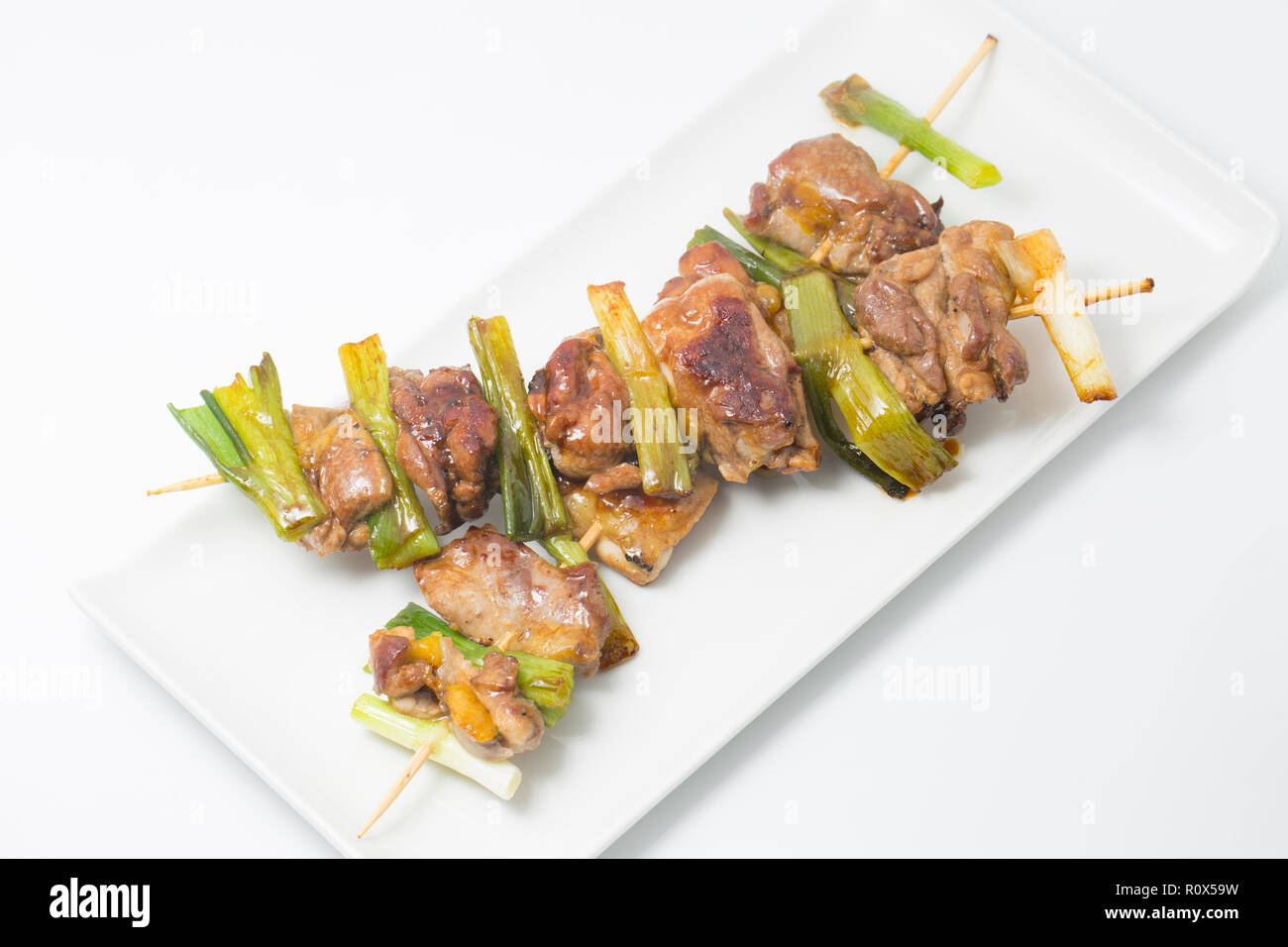 Home-cotto pezzi di fagiano carne di coscia di un fagiano shot su una condotta gameshoot. Essi sono stati infilzato su spiedini di bambù con cipolline e Foto Stock