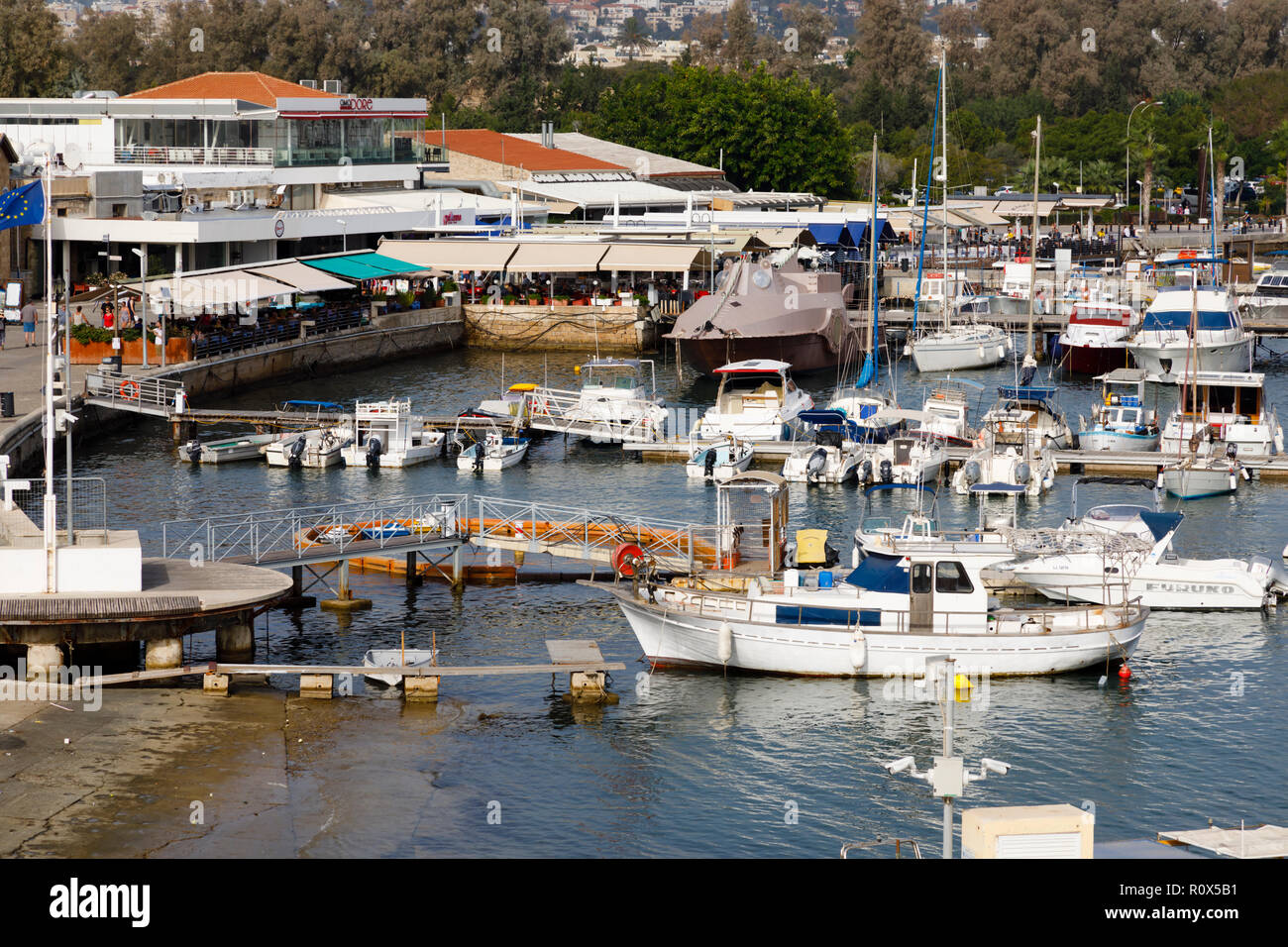 Barche ormeggiate nel porto di Paphos. I ristoranti sulla banchina sono pieni di turisti. Cipro Ottobre 2018 Foto Stock