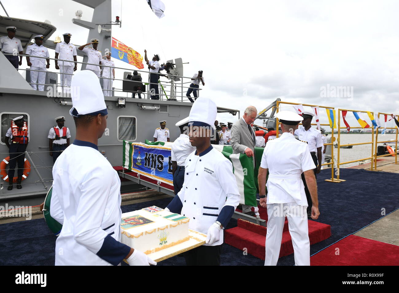 La marina militare nigeriano portano una torta di compleanno cucinati dal navy chef, per il Principe di Galles, durante la sua visita a Lagos Naval cuccette in Nigeria il giorno otto del loro viaggio in Africa occidentale. Foto Stock