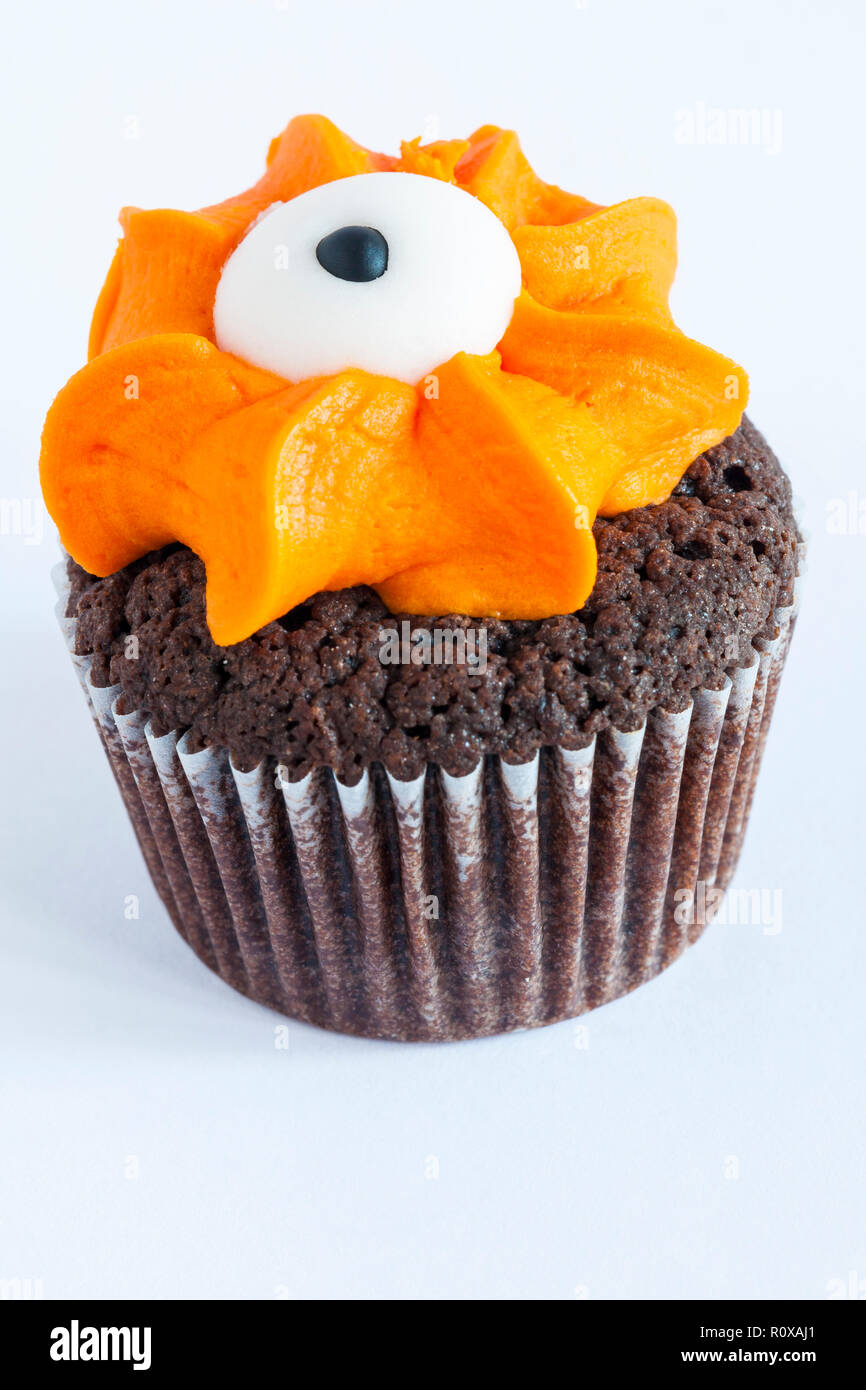 M&S mini monster cupcake cioccolato & torta arancione finito con glassa fondente eyeball isolato su sfondo bianco da mini monster cupcake selezione Foto Stock
