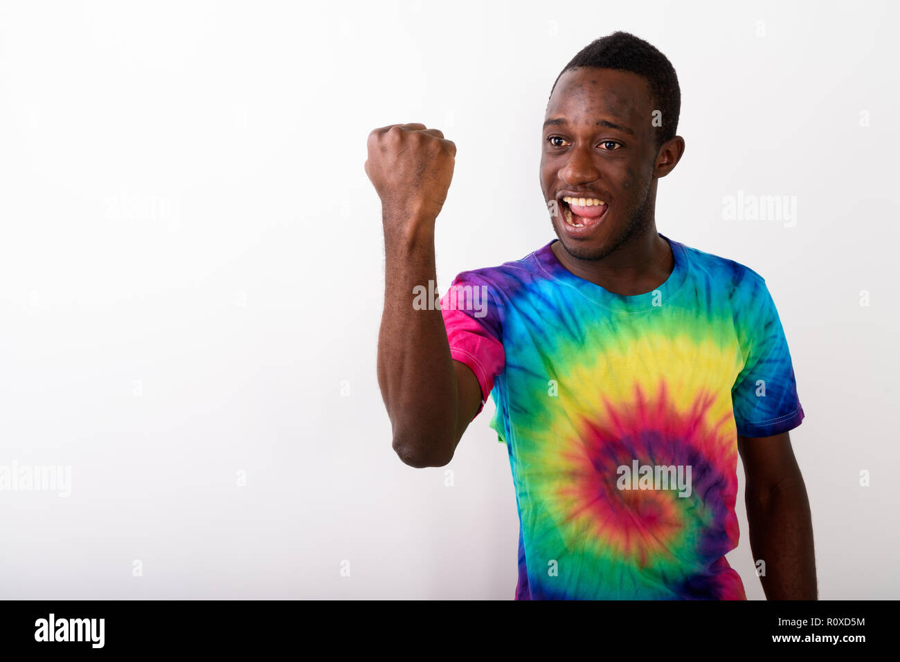 Studio shot di giovani felici Africano nero uomo con il braccio sollevato loo Foto Stock