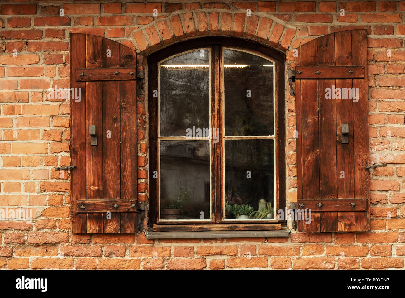 Vecchia finestra con persiane di rosso e un muro di mattoni Foto Stock