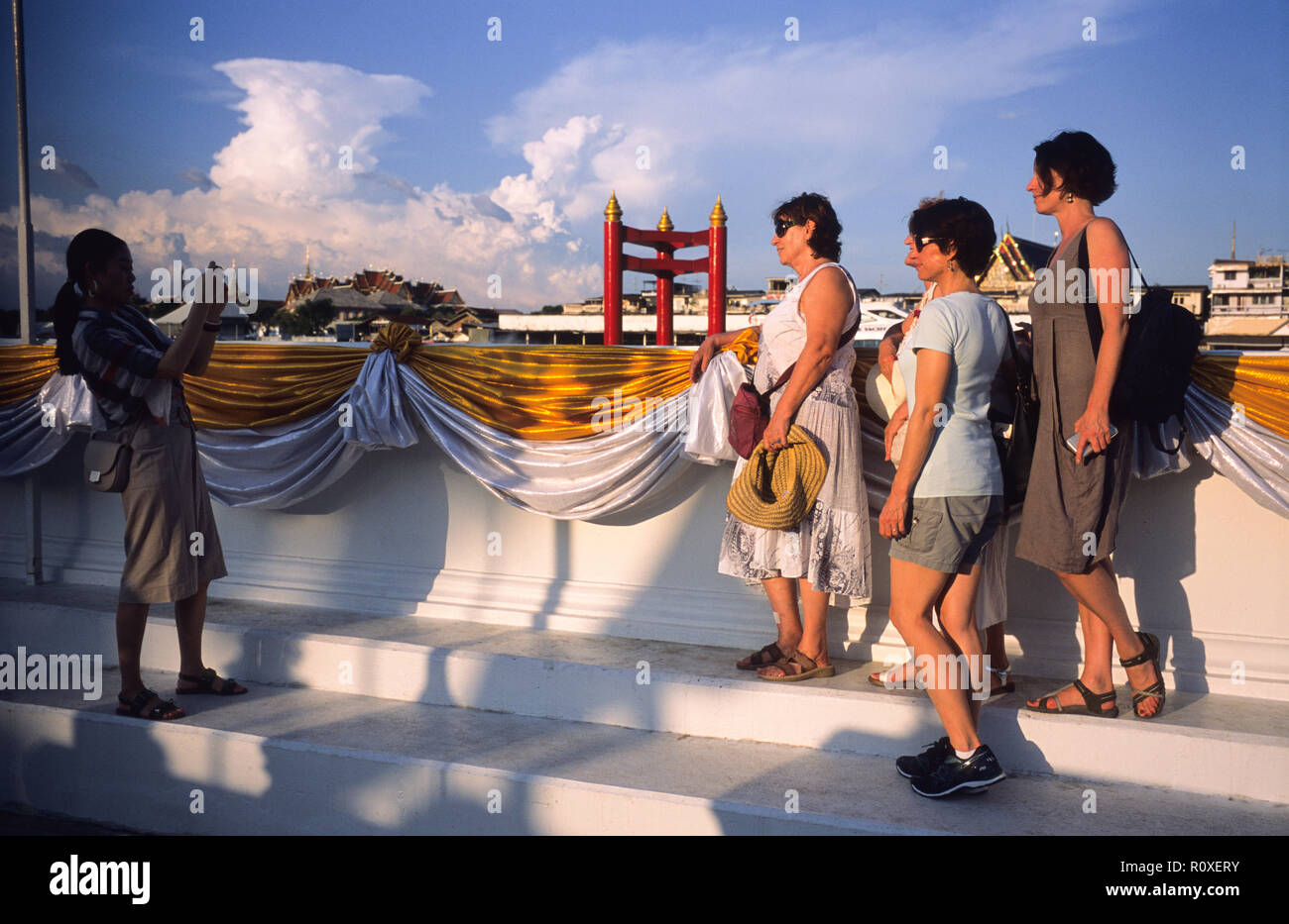 Turisti europei aventi le loro foto scattata da un visitatore locale, Wat Arun, Bangkok, Thailandia. Foto Stock