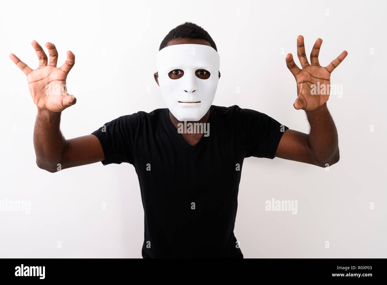 Studio shot del giovane africano nero uomo che indossa la maschera e mostra Foto Stock