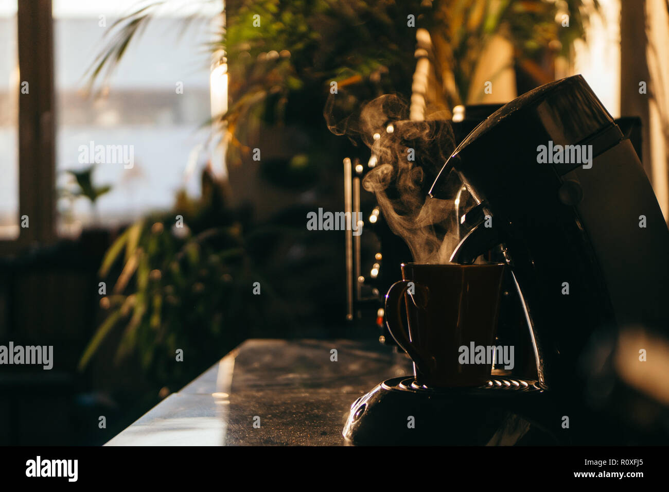 Immagine di una tazza che è sempre riempita con vapore caldo il caffè dalla macchina per caffè Foto Stock