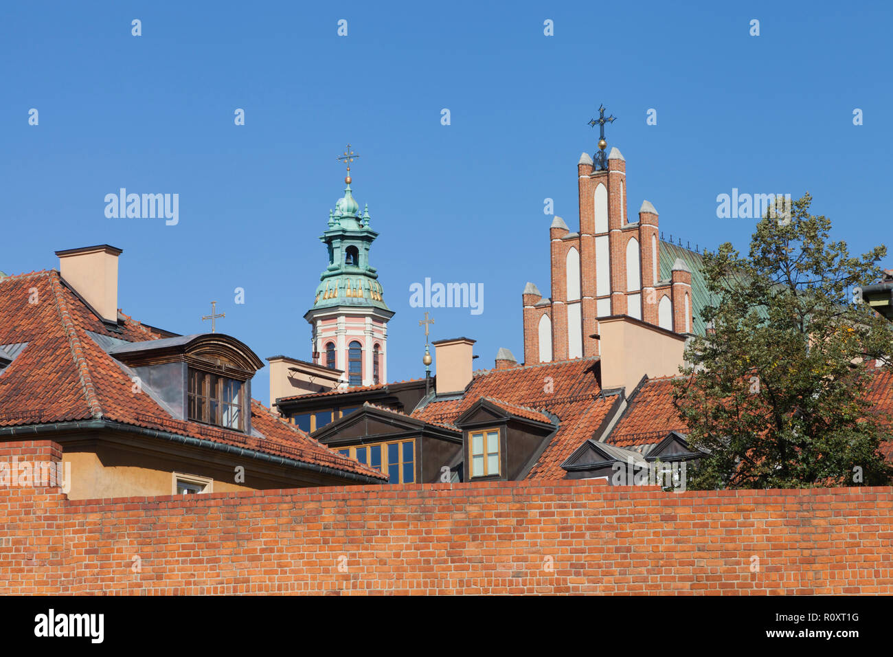 Chiese, tetti rossi di vecchi edifici rosso dietro un muro di mattoni nella storica Città Vecchia, Varsavia, Polonia . Foto Stock