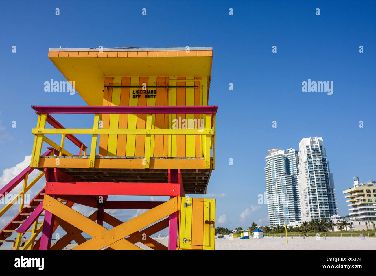 Miami Beach Florida, spiaggia pubblica, sabbia, riva, bagnino stand, torre, off-duty, striscia, colore luminoso, arancione, giallo, cartello, edificio, grattacielo alto grattacielo Foto Stock