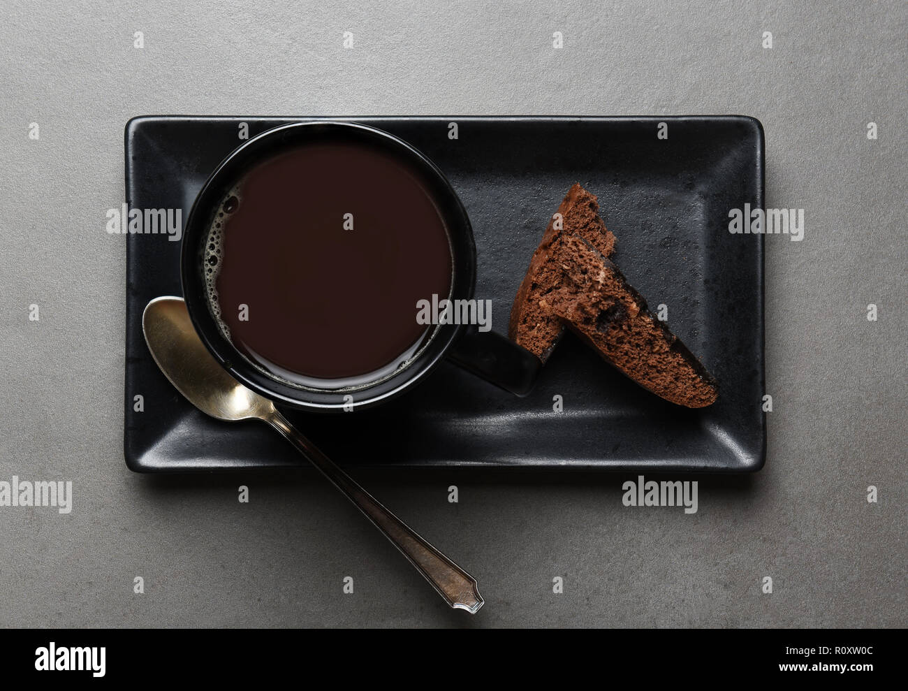 Vista aerea di una tazza di caffè e biscotti al cioccolato su una piastra rettangolare su un grigio ardesia tabella. Foto Stock