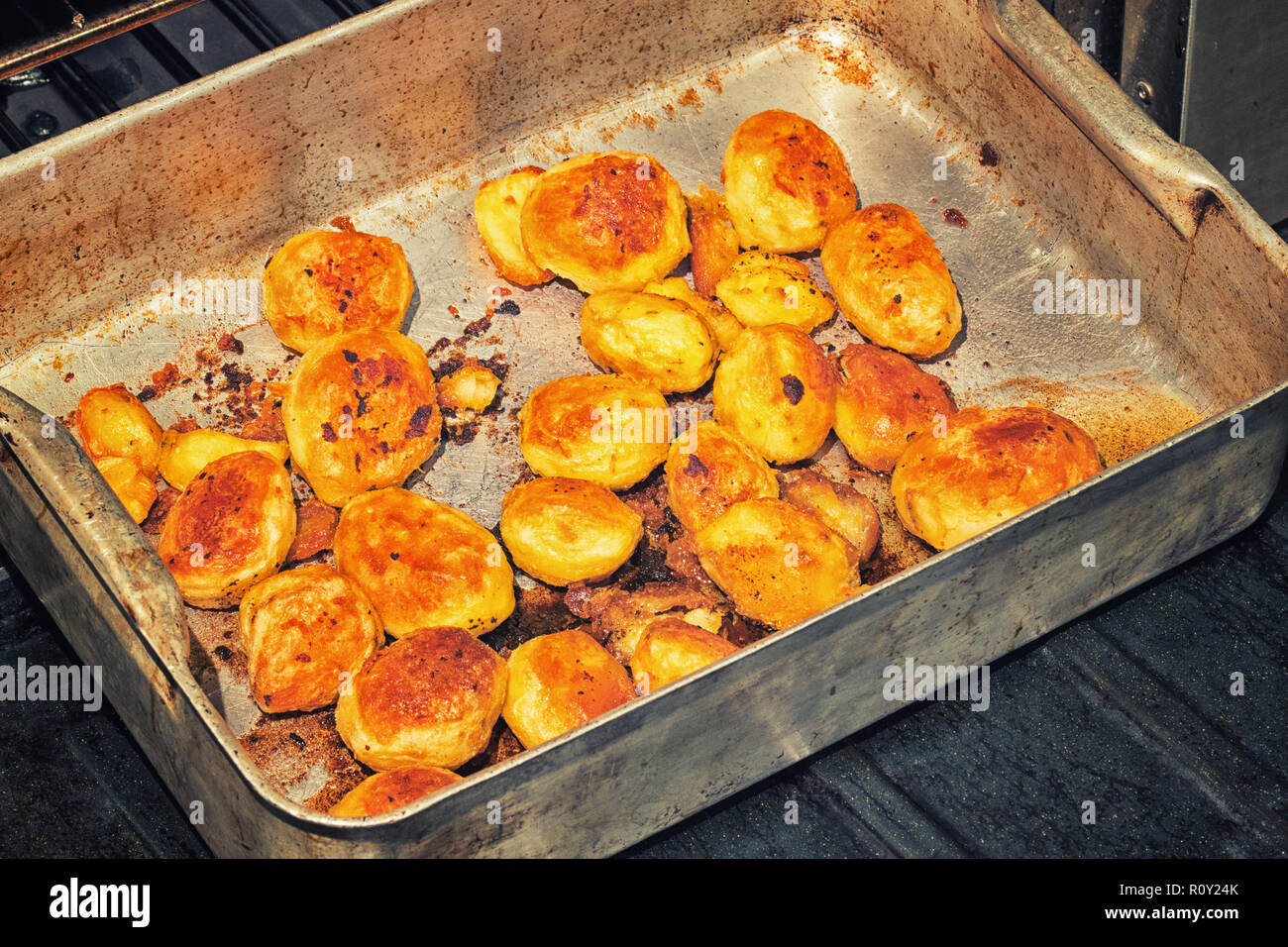 Il vassoio di cottura croccante di patate arrosto pronto a servire come parte di inglese tradizionale arrosto della domenica a cena. Foto Stock