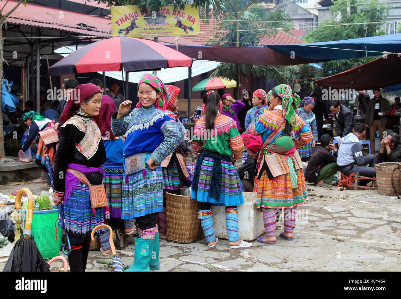 Le donne si radunano intorno a merci in vendita a Bac Ha mercato domenicale, Vietnam Foto Stock